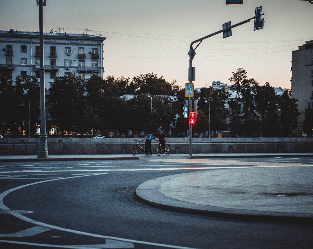 Курьер на велосипеде с большим термо-рюкзаком быстро едет по городу, солнечный день